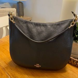 Coach black shoulder bag with detachable crossbody strap.